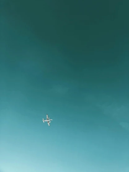 an airplane flying through the sky above trees