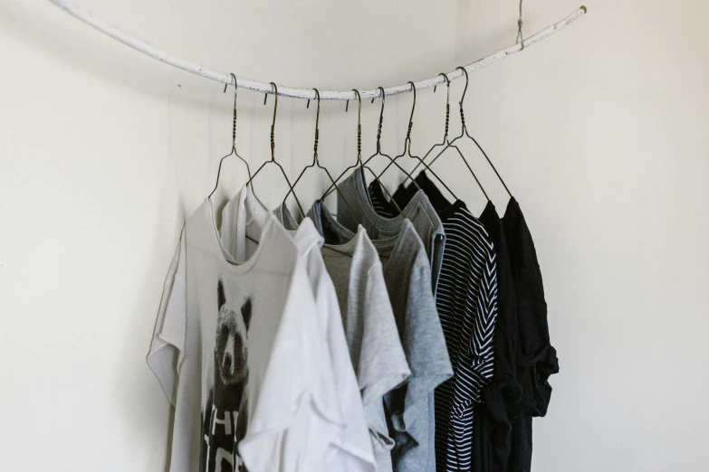 clothes hanging from clothesline against wall and white background
