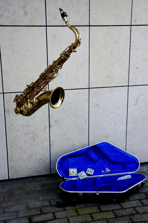 a saxophone is laying on the ground in front of a brick wall