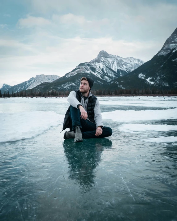 a person is sitting on some ice on the water