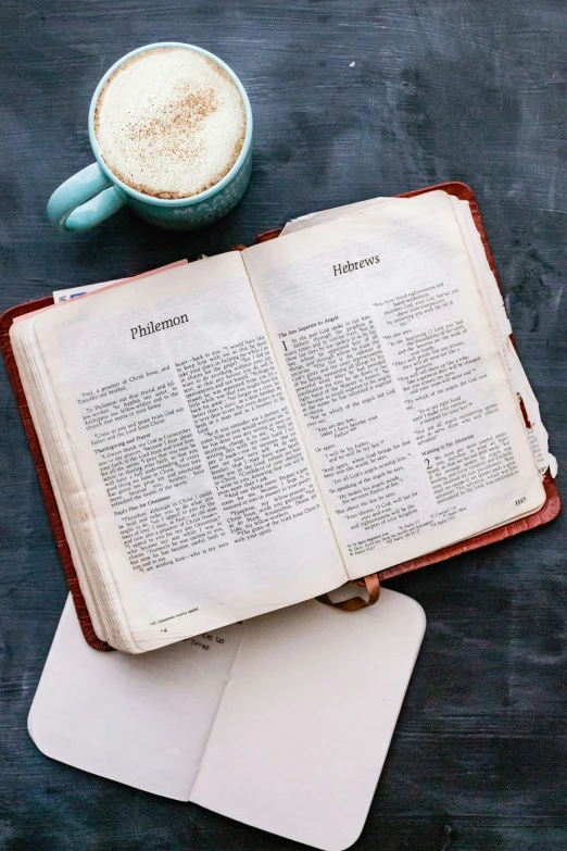 an old open book sitting on top of a table