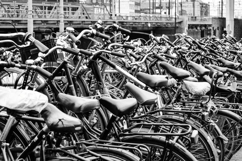 many bicycles parked close together in black and white