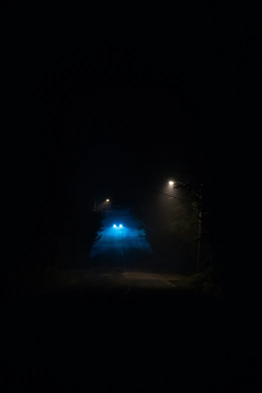 a blue illuminated umbrella in the dark with the lights on