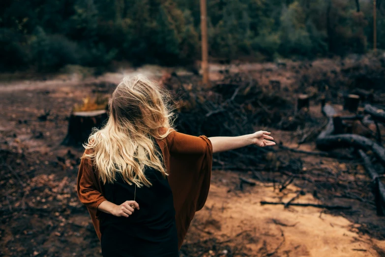 a blonde woman is holding her arms out and pointing