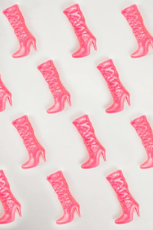 a couple of pairs of pink high heel boots sitting on a white surface