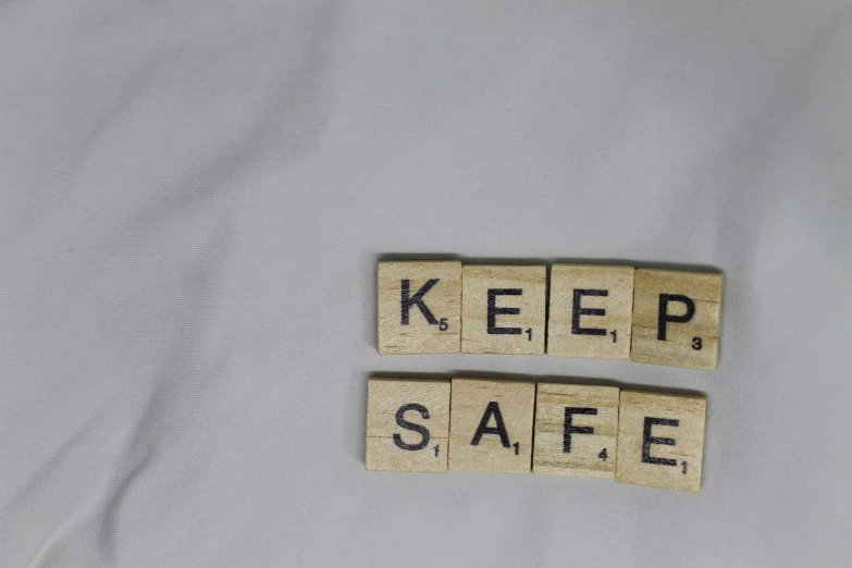 two wooden scrabble letters with the word keep safe written on them