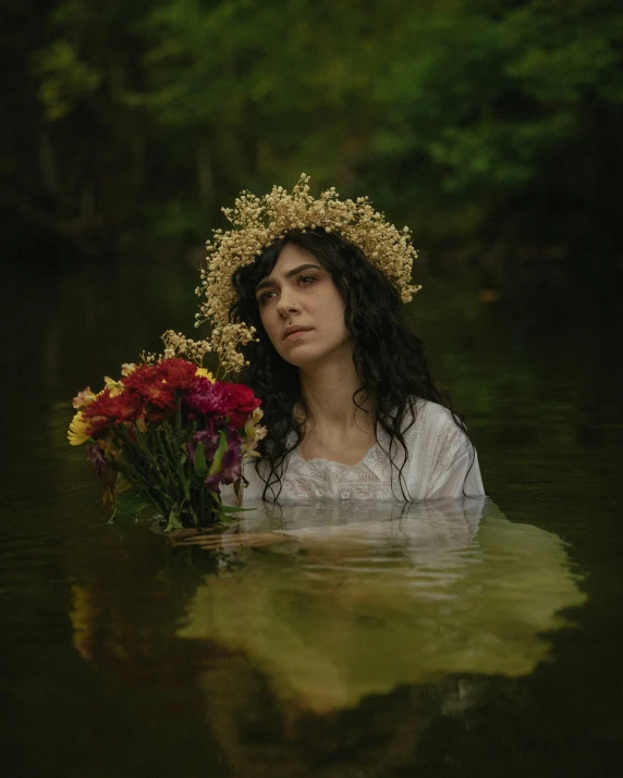 a woman submerged in water with a bouquet of flowers