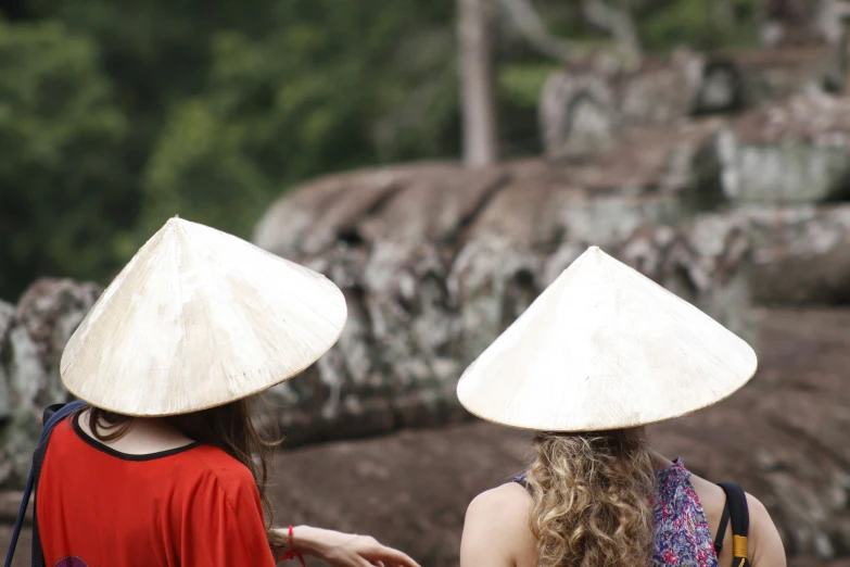 two women standing by a rock face each other