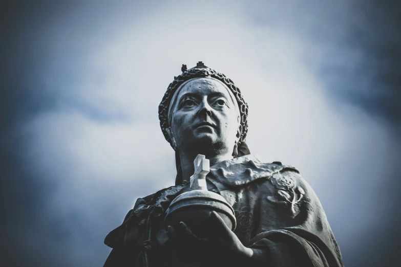 an ornate statue is holding his hands to his mouth