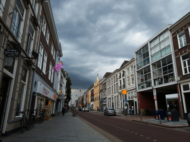 street scene with storm clouds and building on left side