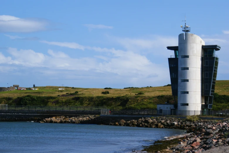 a very tall tower sits next to the water