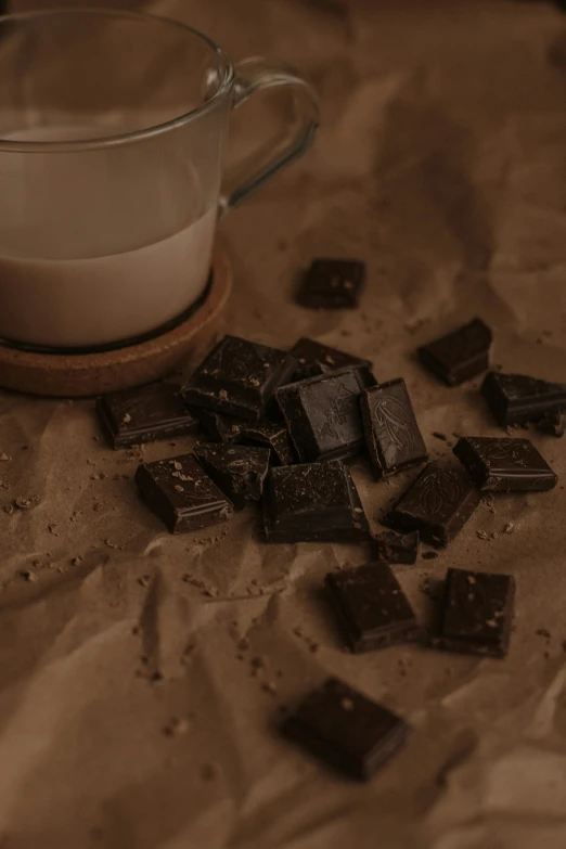 some chocolates spilled next to a glass of milk