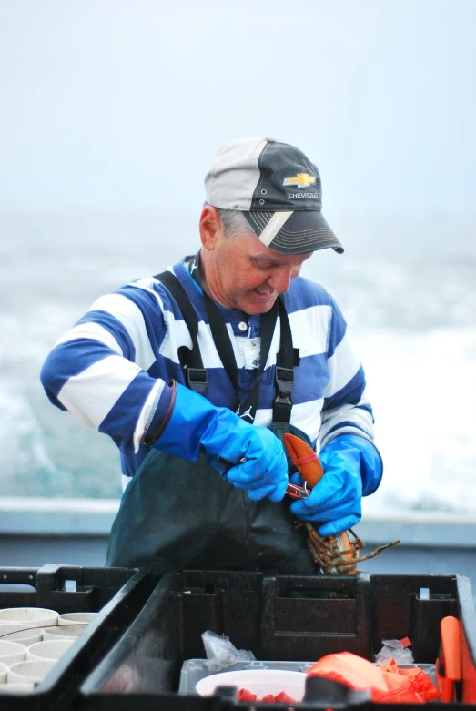 an older man fishing off the coast in the rain