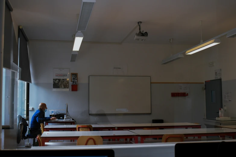 a woman standing at the edge of a classroom