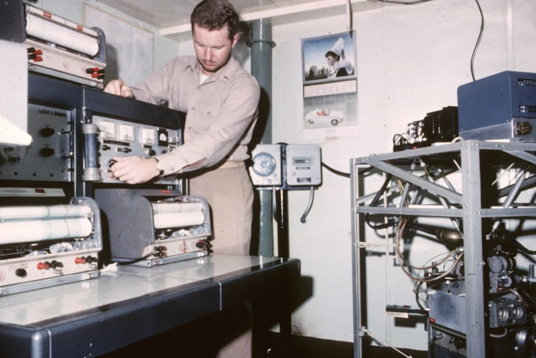 a man looks down at a collection of electronics