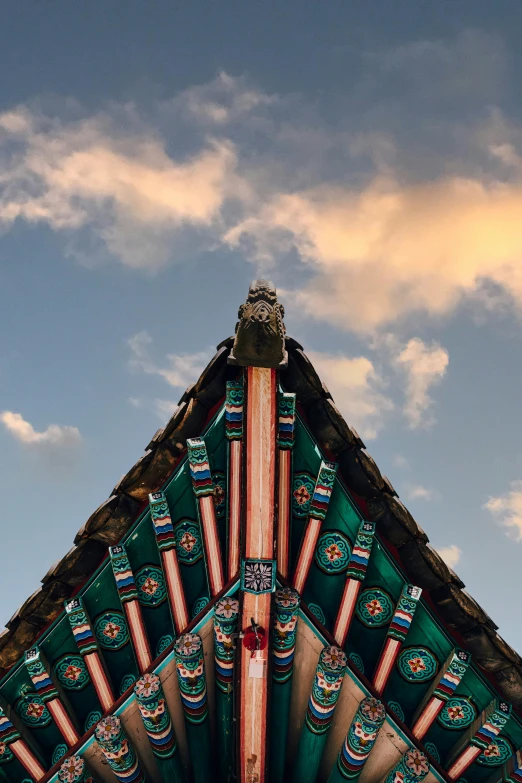 the roof of a building with decorative detailing in green and red