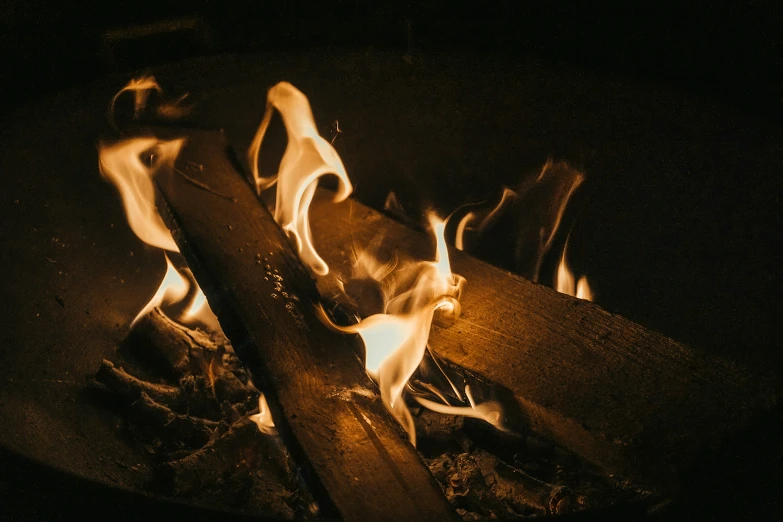 flames burning in the dark with sticks and logs