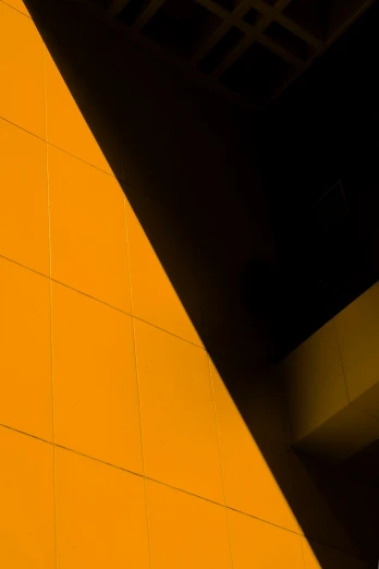 a yellow wall with a bench under a roof