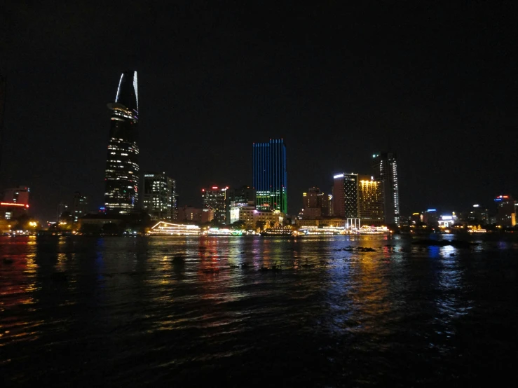 the view of a river and city at night from the side of the river