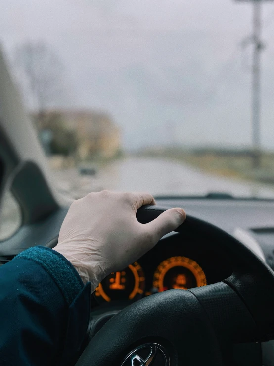 a hand holding the steering wheel while driving