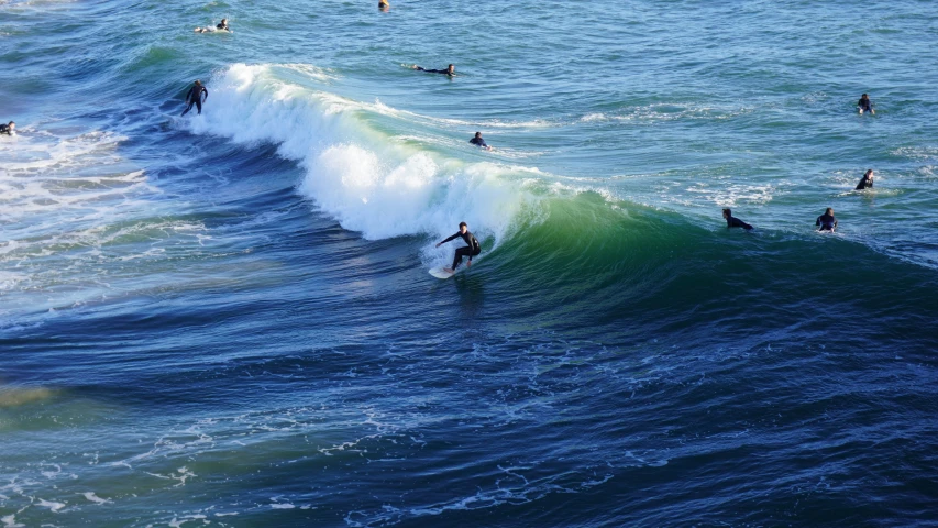 several people are surfing on an ocean wave