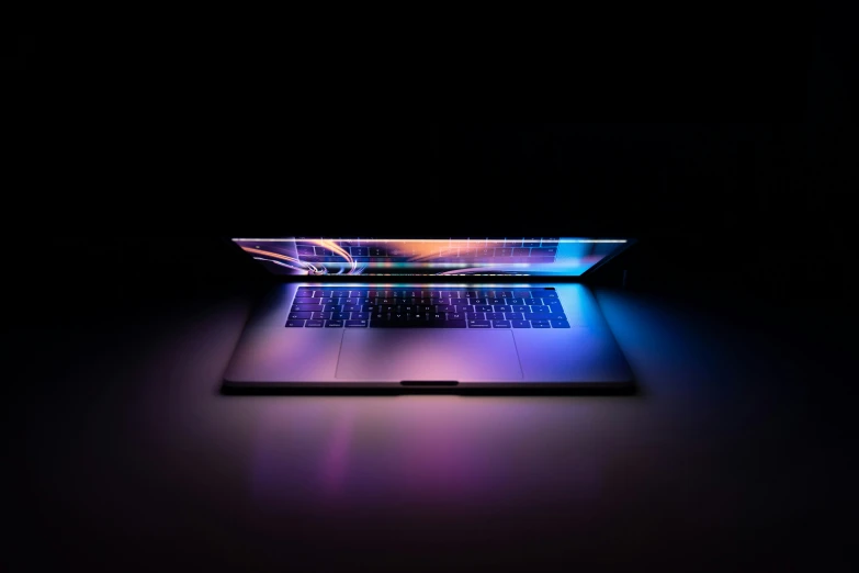 a laptop computer with a purple and blue keyboard on the top