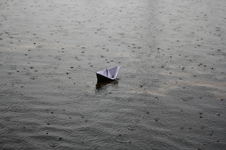 a small paper boat floating on top of a lake