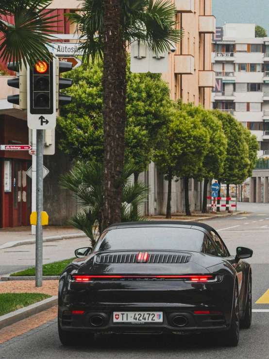 a car driving in the street next to a traffic light