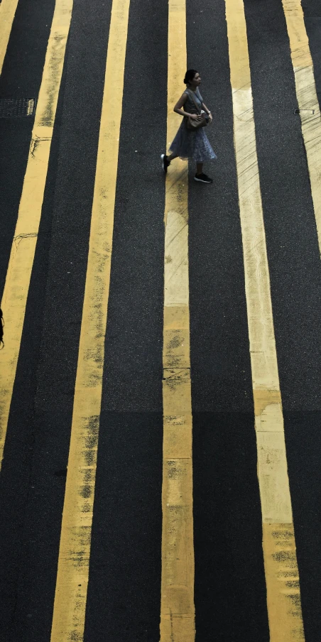 a person crossing the street holding an umbrella