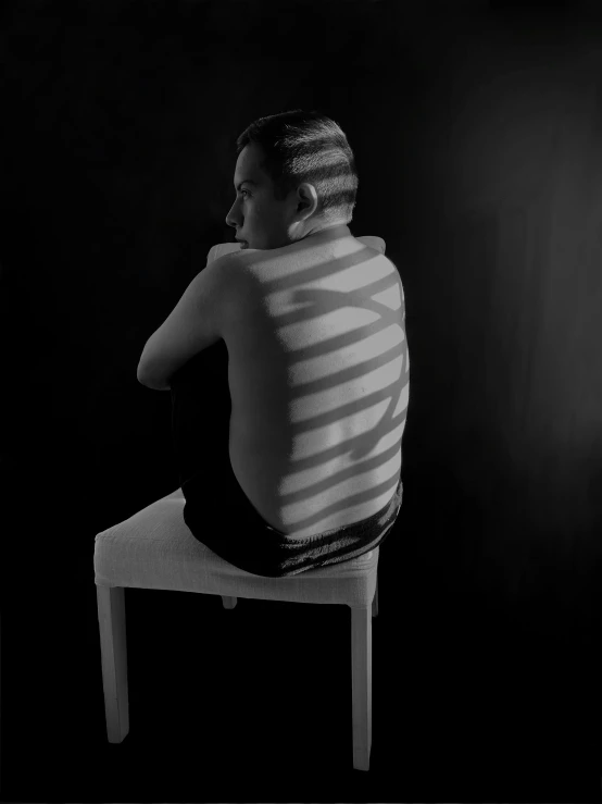 a person sitting on a chair with a towel over their back
