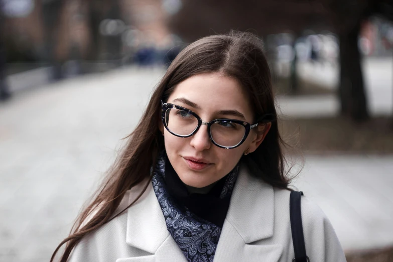 a young lady wearing glasses and a sweater