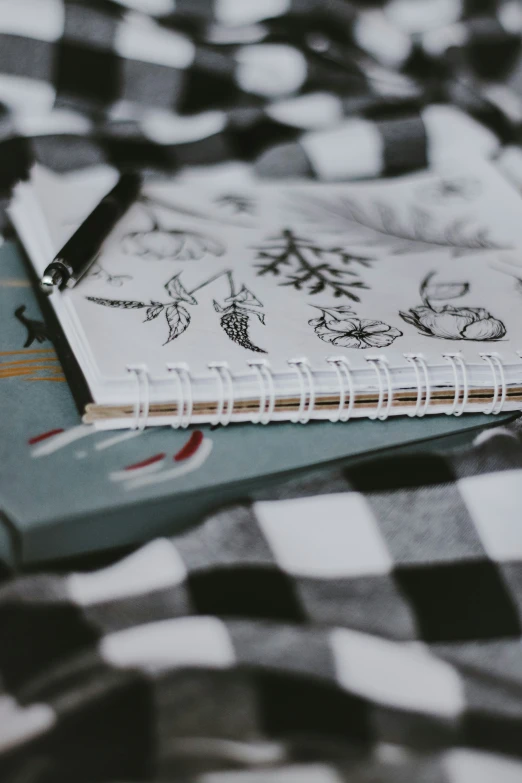 a notebook with drawings sitting on a bed