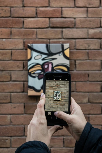 someone is holding their phone up to a wall with a colorful face