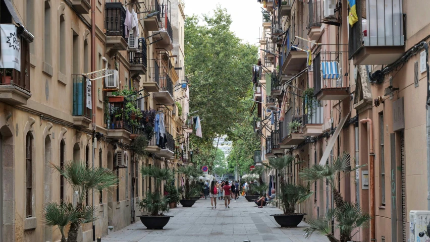 a narrow street in a european city with people on the sidewalks