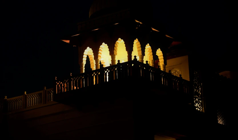 a balcony in a building lit up at night