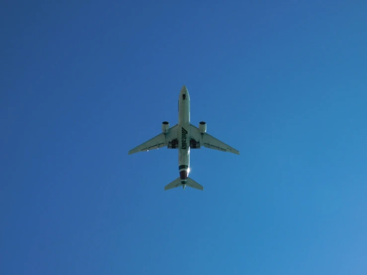 an airplane flying in the air during a sunny day