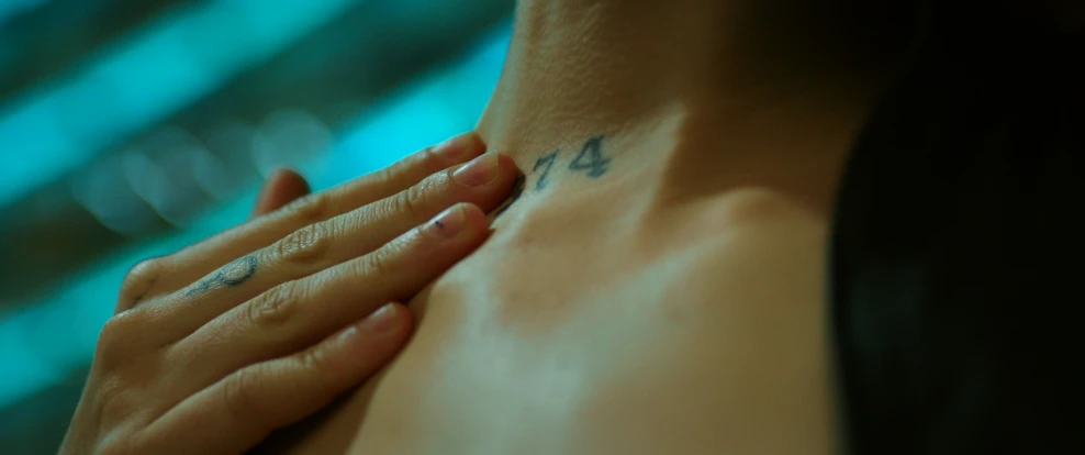 a woman has her arm wrapped around her neck with numbers on it