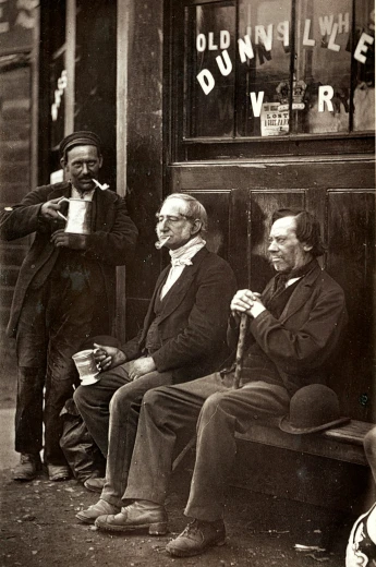 a black and white pograph of three old gentlemen sitting outside
