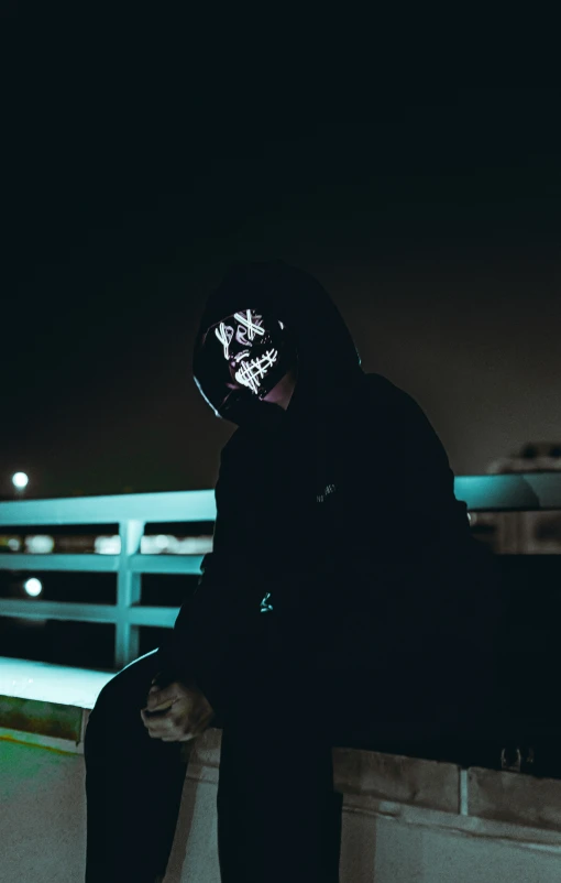 man sitting on concrete ledge next to water