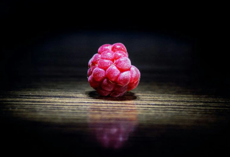 there is a raspberry on the ground on the table