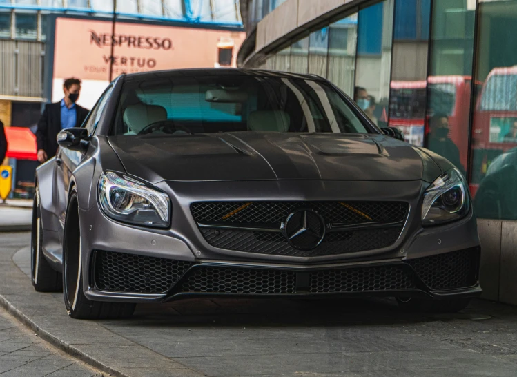 grey mercedes benz sports sedan parked outside a store