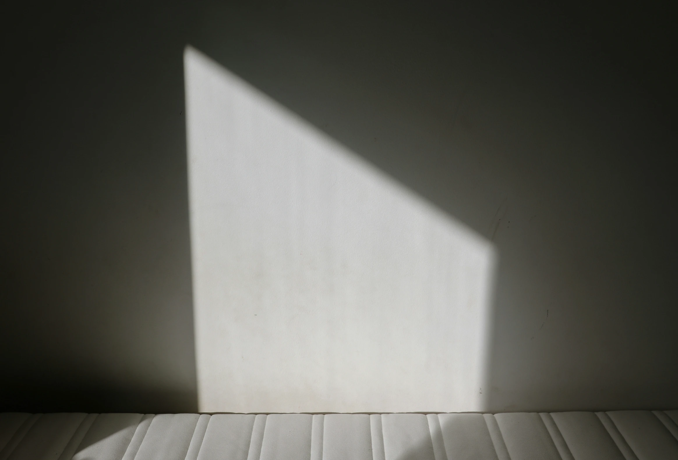 a shadow is cast from the side of a white box
