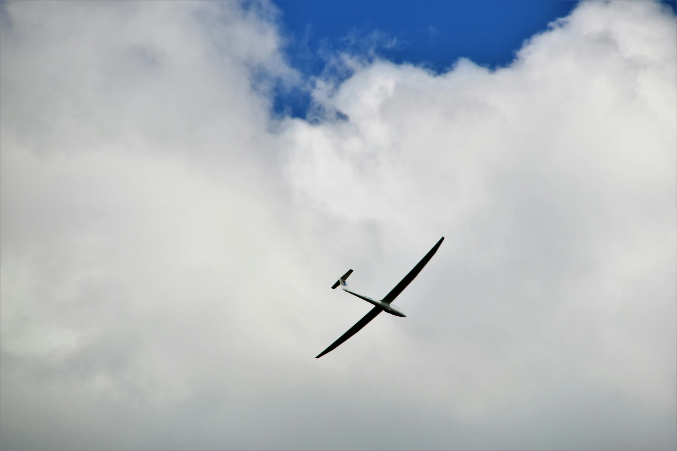 an airplane flying through the air, with clouds