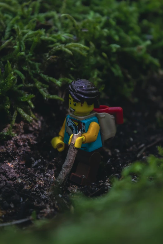 a lego person that is standing in the grass