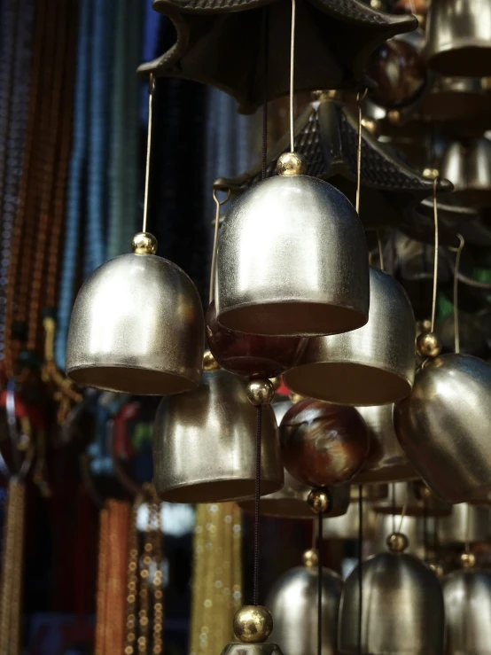 a group of shiny bells hanging from the ceiling