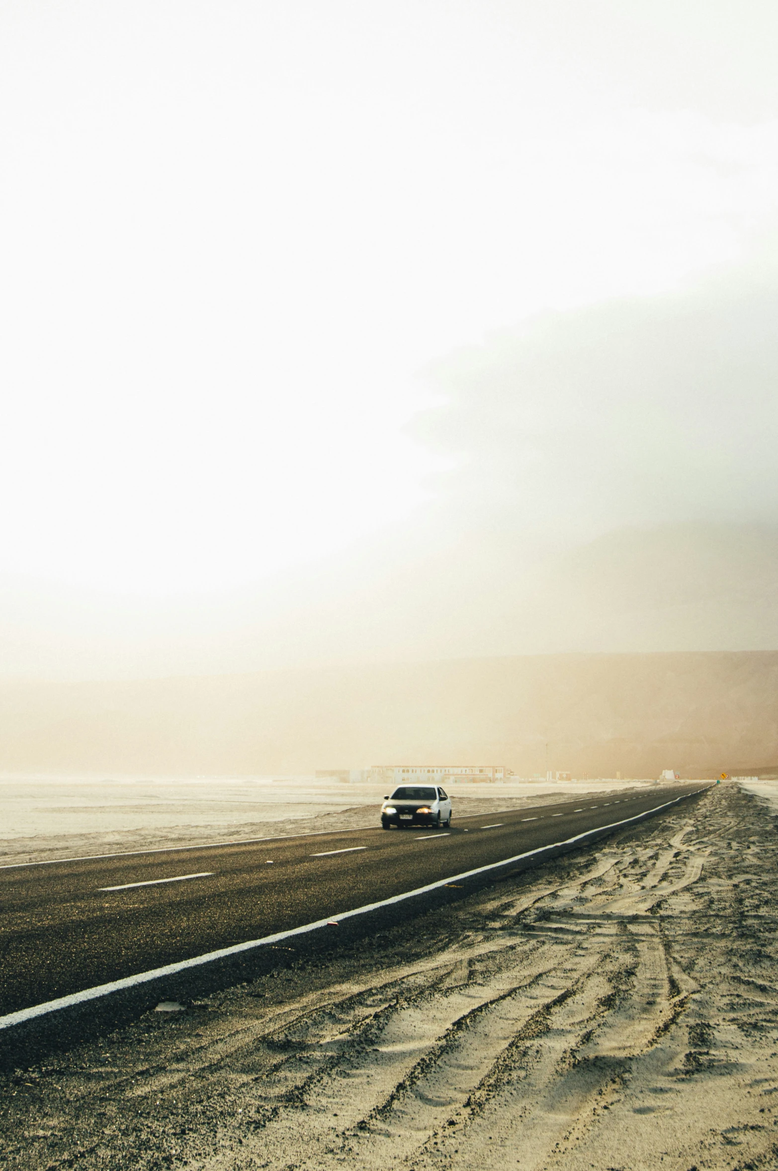 a car traveling down the road in the desert