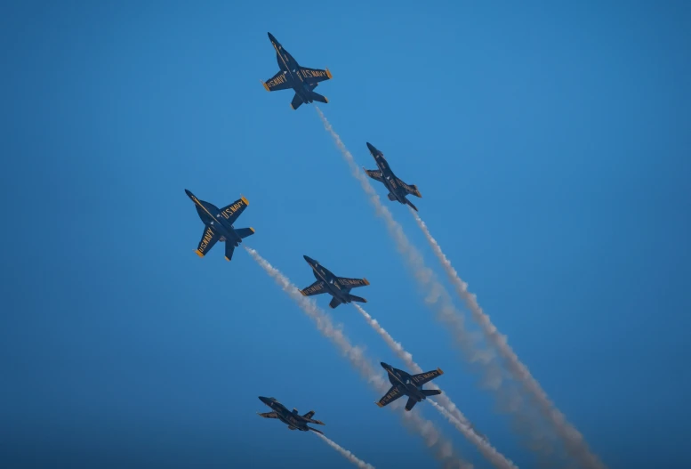 four fighter jets are in formation and are performing stunts