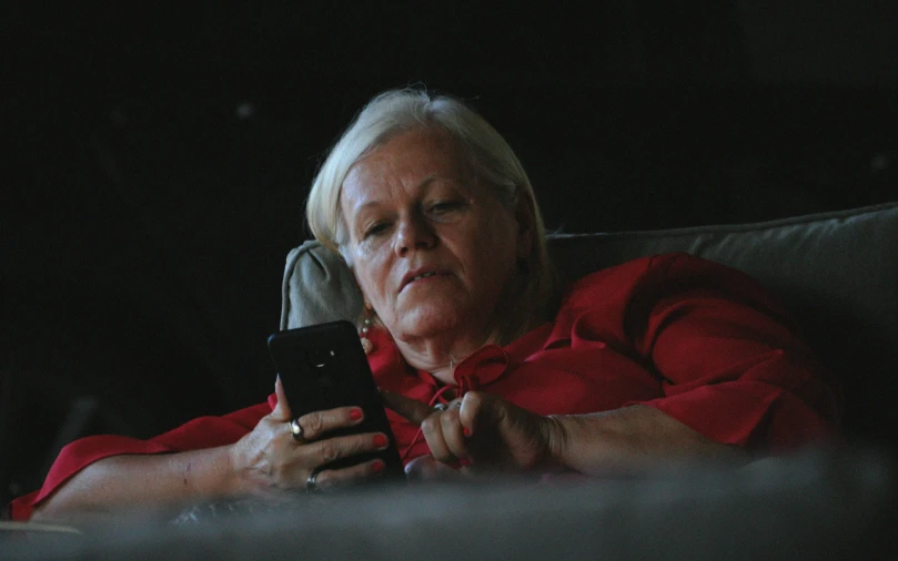 a woman with blonde hair looking at her cell phone