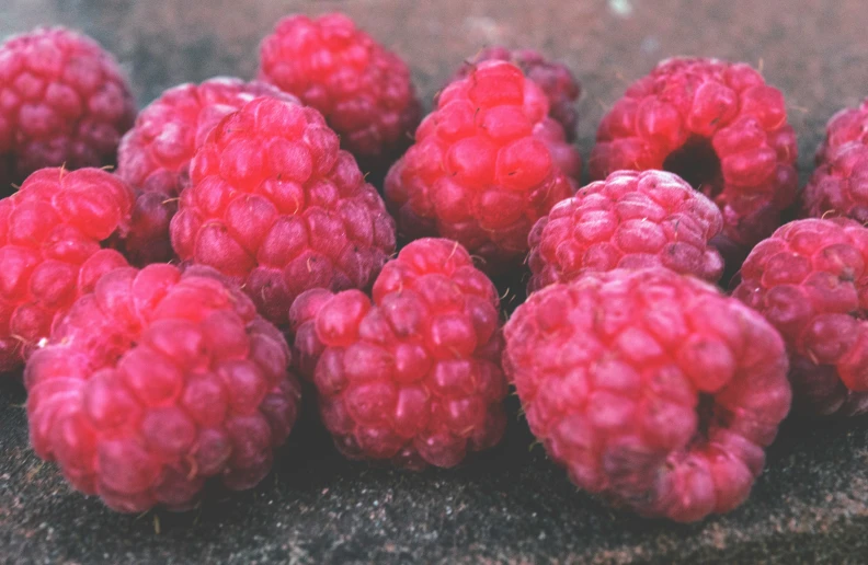 some very ripe raspberries laying down on the ground