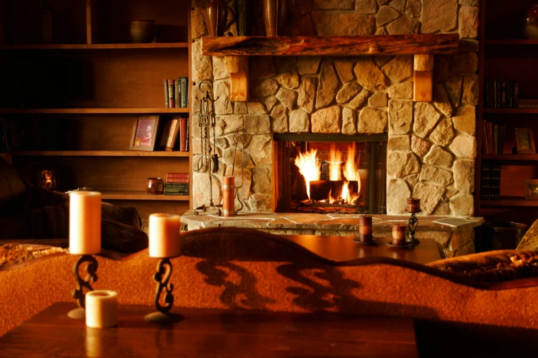 a fire place is lit next to a book shelf